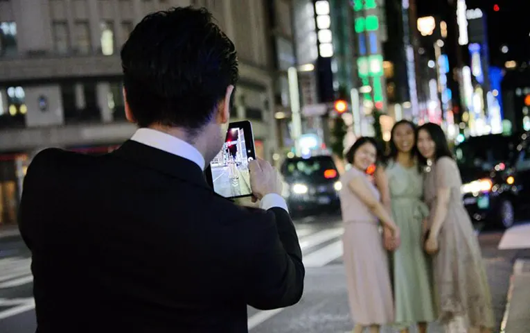 A planner (driver-guide) assisting guests with a commemorative photo
