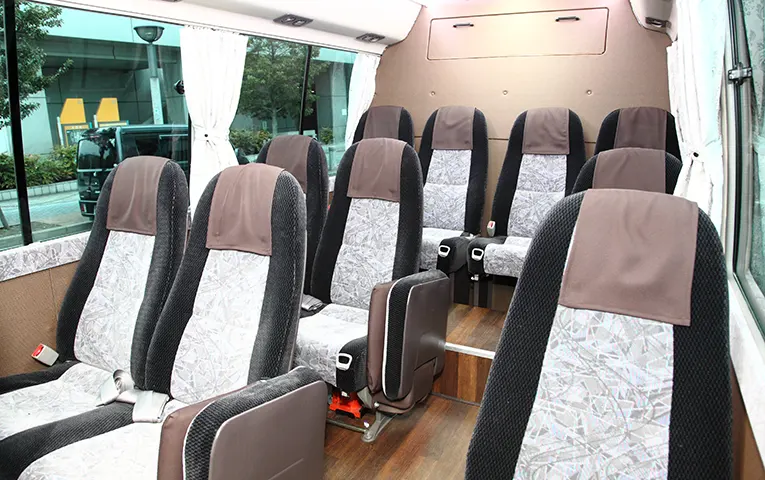 Bus interior accommodating a small group of about 20 people.